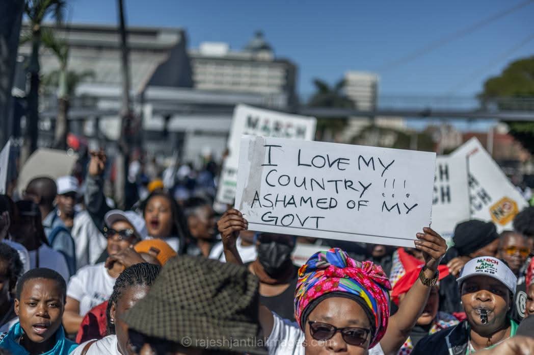 Protester holding sign at waterfront rally with message of national pride